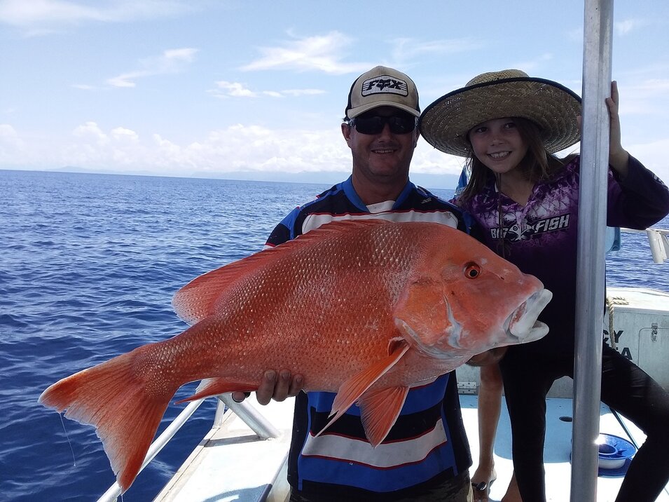 male and young female angler holding a red emperor
