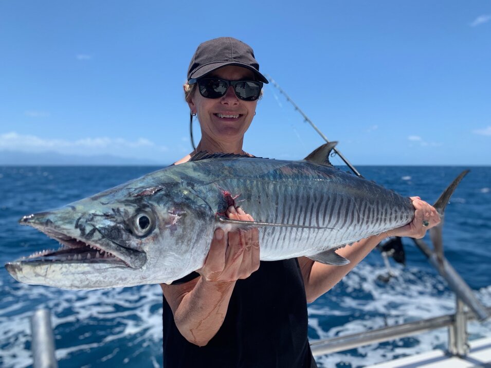 Angler holding a freshly caught Spanish mackerel