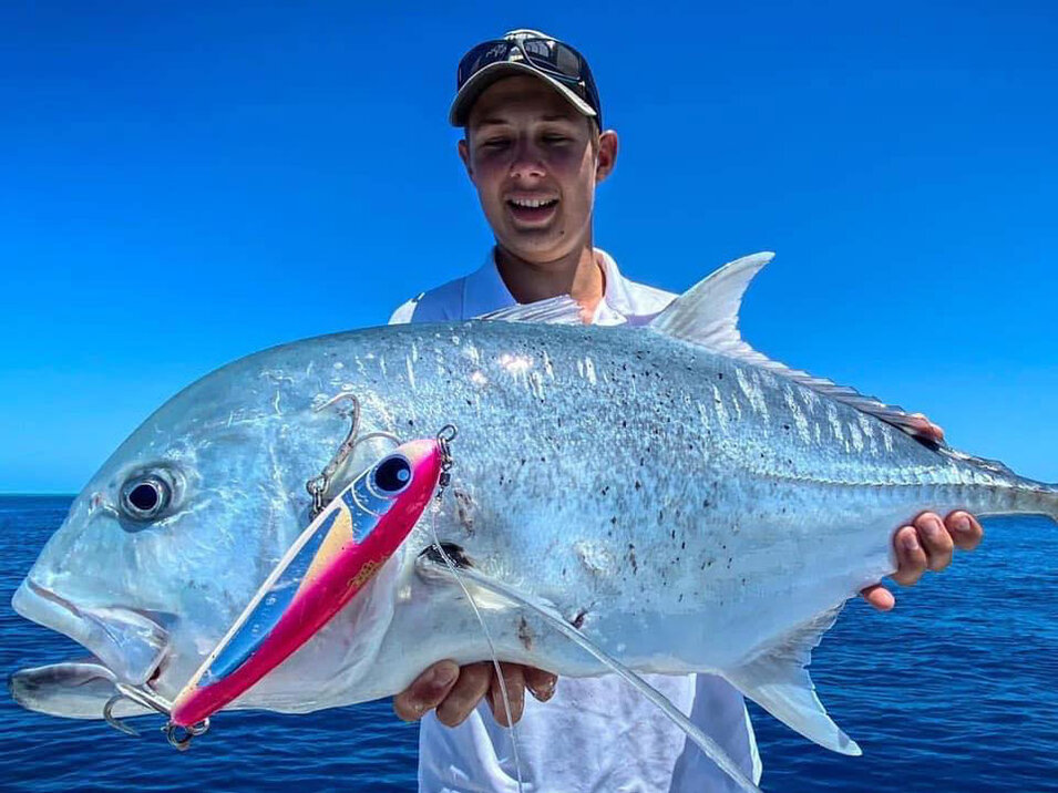 Angler showing his catch of a Giant Trevally