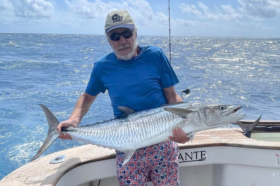 An angler holding his freshly caught Spanish mackerel